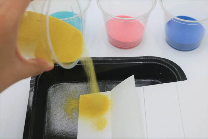 It's easy to create colorful sand art with adhesive or sticky boards.